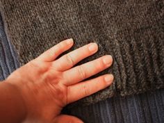 a person's hand on the back of a sweater