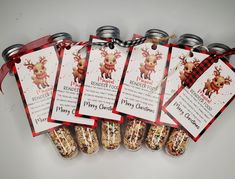 six christmas gift tags with reindeers on them are hanging from mason jars filled with food