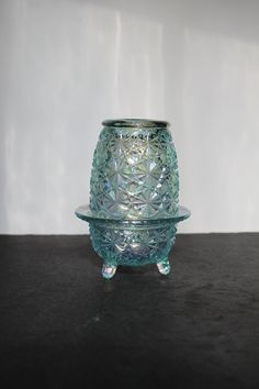 a glass candle holder sitting on top of a table