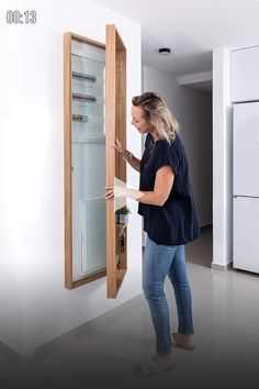 a woman is opening the door to a refrigerator