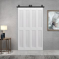 a living room with a white door and brick wall