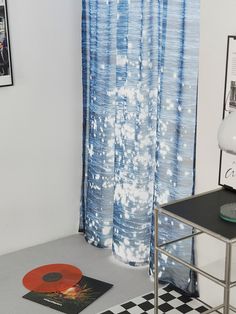 a black and white checkered floor in front of a blue curtain