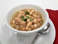 a white bowl filled with beans on top of a plate