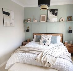 a bed with white sheets and pillows in a room