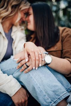 two women sitting next to each other with their hands on one another's lap