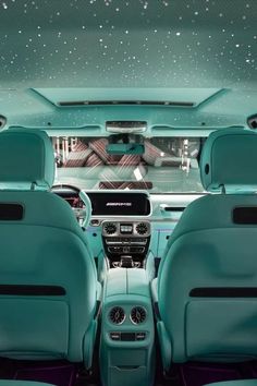 the interior of a car with blue leather seats and stars on the ceiling above it