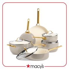 a set of pots and pans with gold handles on a white background, all in different sizes