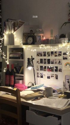 a cluttered desk with lots of pictures and lights on the wall above it,