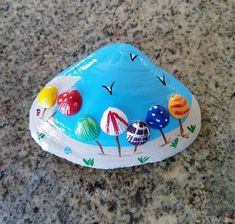 a blue rock with different designs and colors on it sitting on a granite counter top