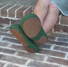 a person wearing green slippers sitting on brick steps