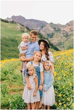 a family posing for a photo in the middle of a field with sunflowers