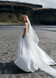 a woman in a wedding dress on the beach