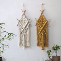 two wall hangings made out of macrame and bamboo sticks on a white wall