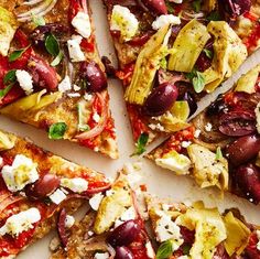 a pizza topped with olives, artichokes and feta cheese