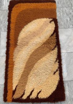 a brown and tan area rug with an animal print on it's side, sitting on a tile floor