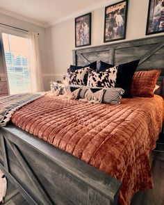 a large bed sitting in a bedroom next to two pictures on the wall above it