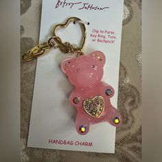 a pink bear shaped keychain with glitters on it