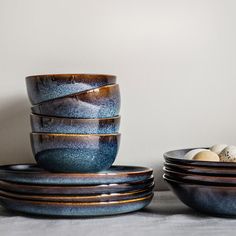 several bowls and plates stacked on top of each other with eggs in the bowl next to them