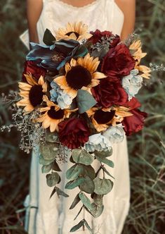 a bridal holding a bouquet of sunflowers and other flowers in it's hands