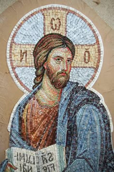 the mosaic portrait of jesus is displayed in front of a wall with a cross on it