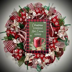 a christmas wreath with red and green decorations on it that says, christmas wishes & hot cocoa kisses