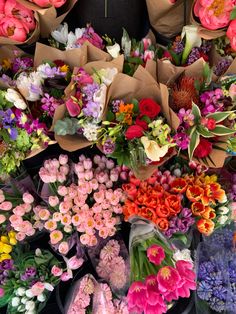 a bunch of flowers that are sitting on some paper bag's in front of each other