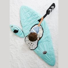 a young boy laying on top of a sleeping bag