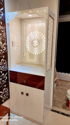 a white cabinet sitting inside of a bathroom next to a window with an omesh symbol on it