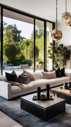 a modern living room with large windows and white couches