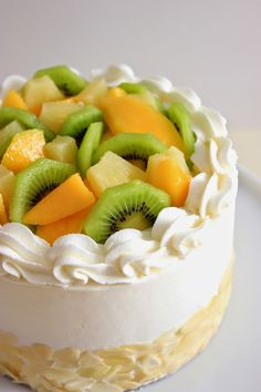 a white cake topped with fruit on top of a table