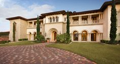 a large house with lots of windows and brick walkway leading to the front entrance area