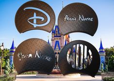 the entrance to disney's castle with four name signs in front of it and blue spires