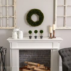 a living room filled with furniture and a fire place covered in wreaths on the mantle