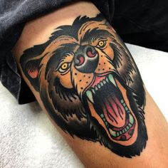 a close up of a tattoo with a lion on it's leg and mouth