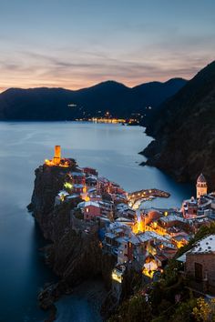 an aerial view of a town on the edge of a body of water at night