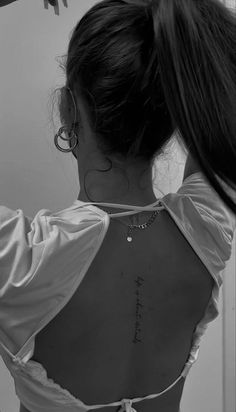 the back of a woman's neck with writing on it