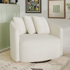 a white couch sitting on top of a rug next to a green cabinet in a living room