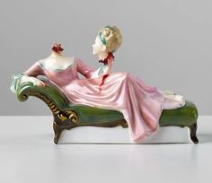 a figurine of a woman sitting on a couch