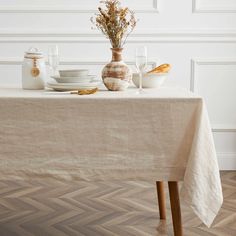 the table is set with dishes and vases