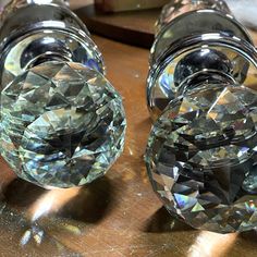 three clear glass vases sitting on top of a wooden table next to each other