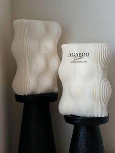 two black and white vases sitting next to each other on top of a table