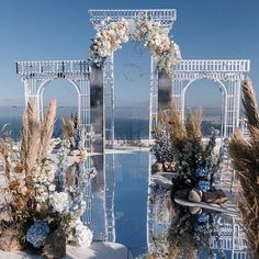 an outdoor wedding setup with flowers and water