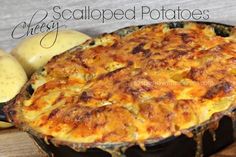 a baked dish with cheese and potatoes on a cutting board