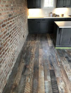 a kitchen with black cabinets and wood flooring in an unfinished room that is being remodeled