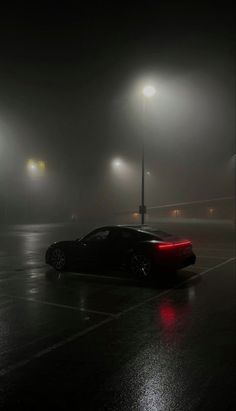 a car parked in a parking lot on a foggy night