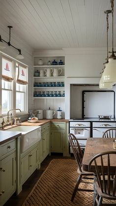 an old fashioned kitchen with green cabinets and white walls, wood flooring and wooden dining table