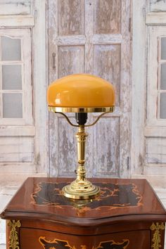 an old fashioned lamp on top of a wooden table in front of a white door