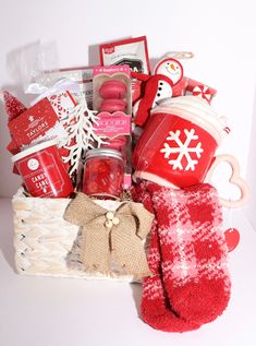 a basket filled with red and white items sitting on top of a table next to a pair of mittens