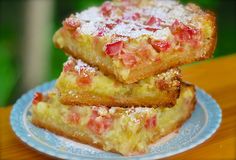 three pieces of cake sitting on top of a blue and white plate with powdered sugar