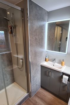 a bathroom with a walk in shower next to a sink